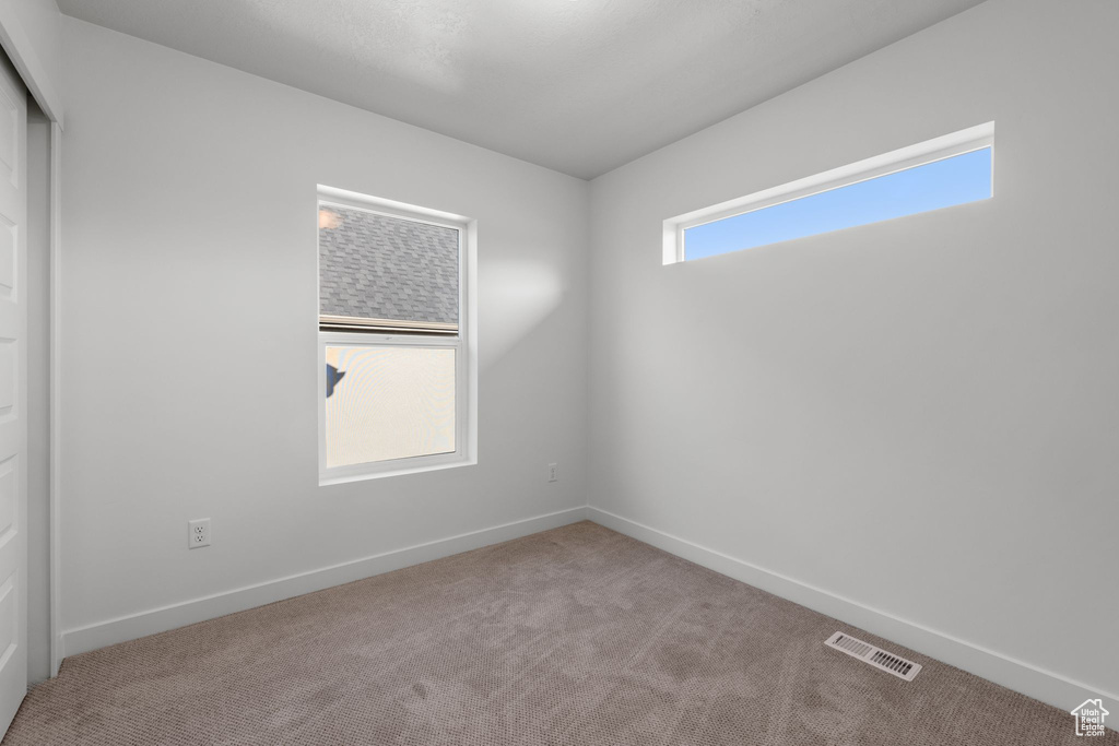 Carpeted empty room with baseboards