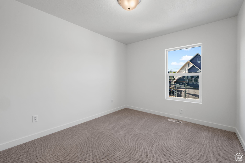 Carpeted spare room with baseboards