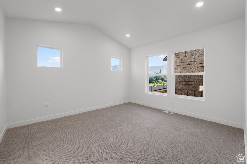 Empty room featuring recessed lighting, carpet flooring, baseboards, and lofted ceiling