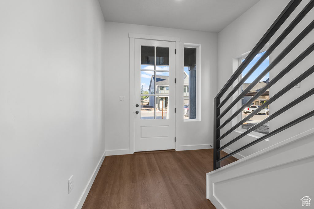 Entryway with stairs, dark wood finished floors, and baseboards