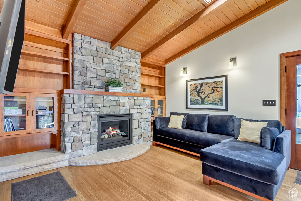 Living area with wood ceiling, wood finished floors, built in shelves, and a fireplace