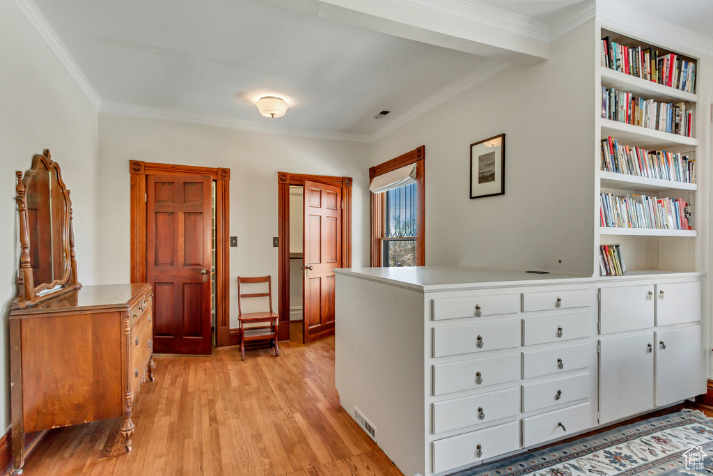 Foyer with ornamental molding and light wood-style flooring