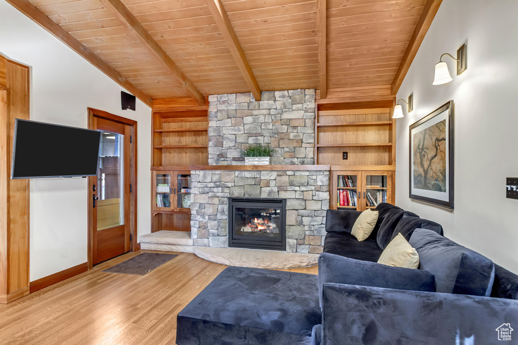 Living area with wood ceiling, wood finished floors, built in shelves, a fireplace, and baseboards