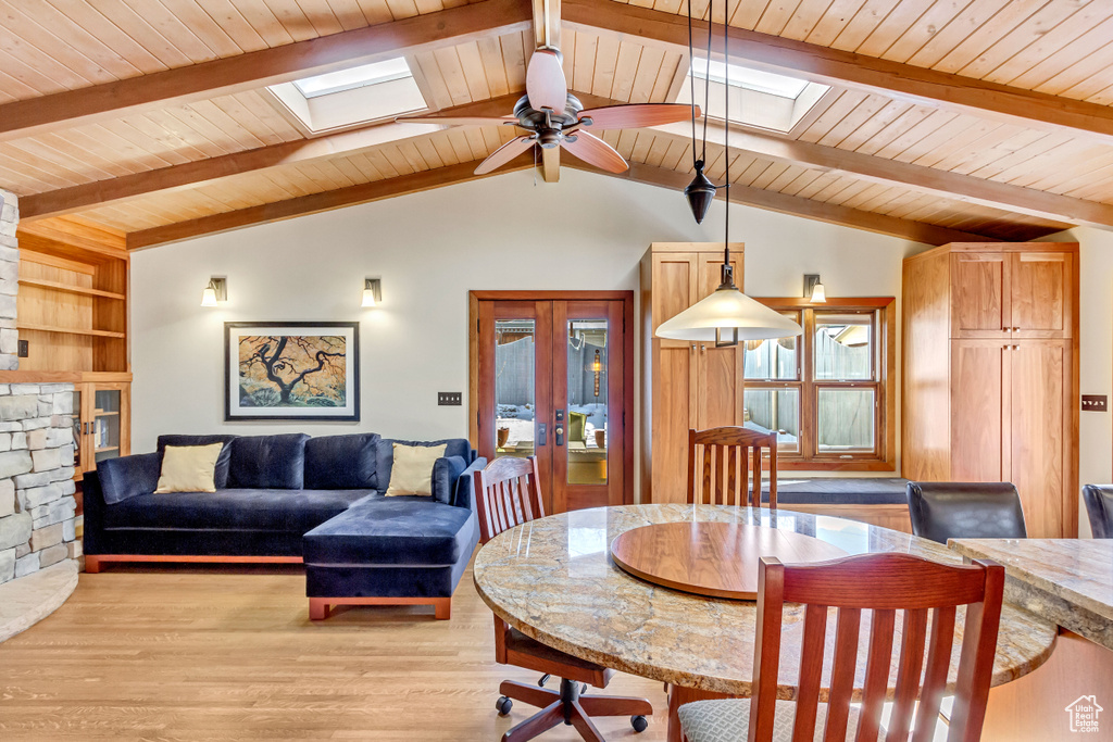 Dining area with a skylight, wood ceiling, french doors, ceiling fan, and light wood finished floors