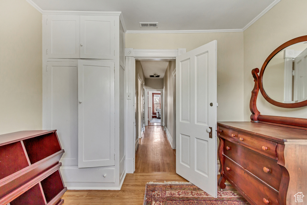 Hall featuring light wood-type flooring and ornamental molding