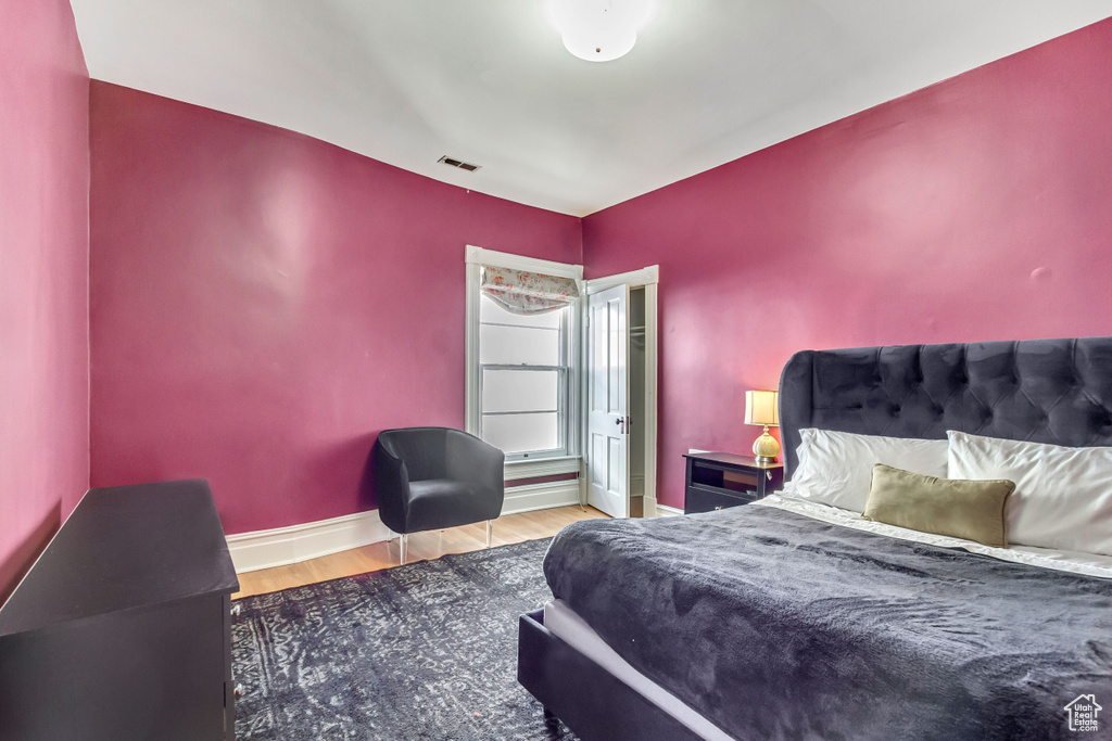 Bedroom with wood finished floors and baseboards