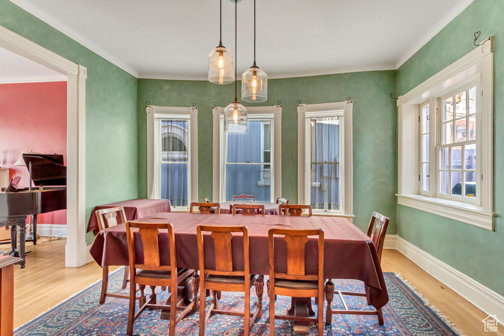 Dining area featuring wood finished floors, ornamental molding, and baseboards