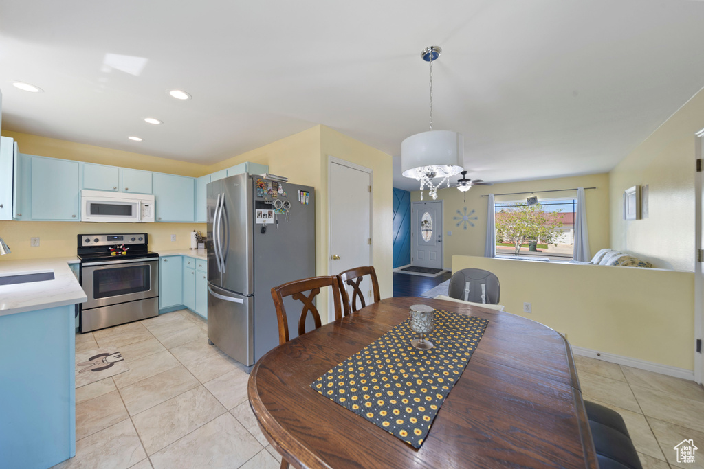 Dining area with light tile patterned floors and recessed lighting