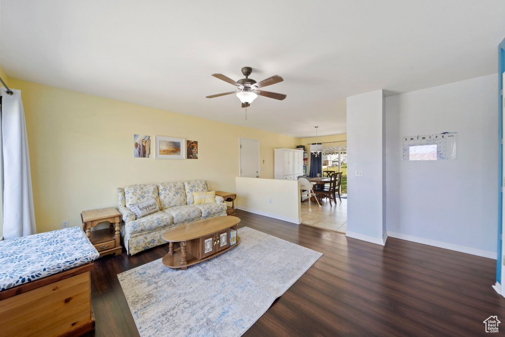 Living area featuring a ceiling fan, wood finished floors, and baseboards
