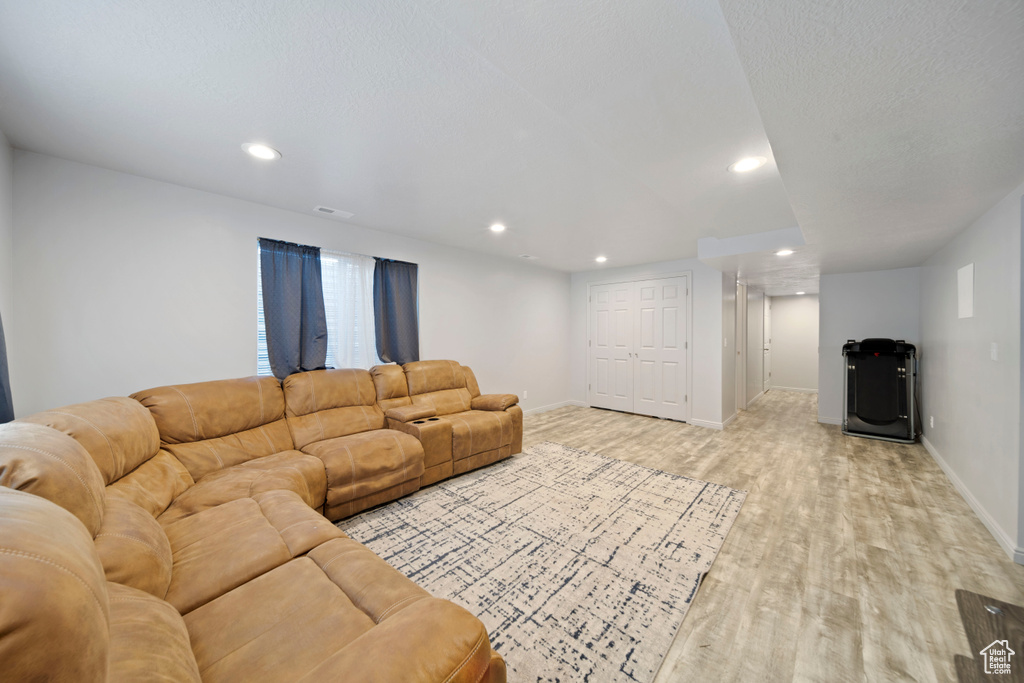 Living area with light wood finished floors, recessed lighting, and baseboards