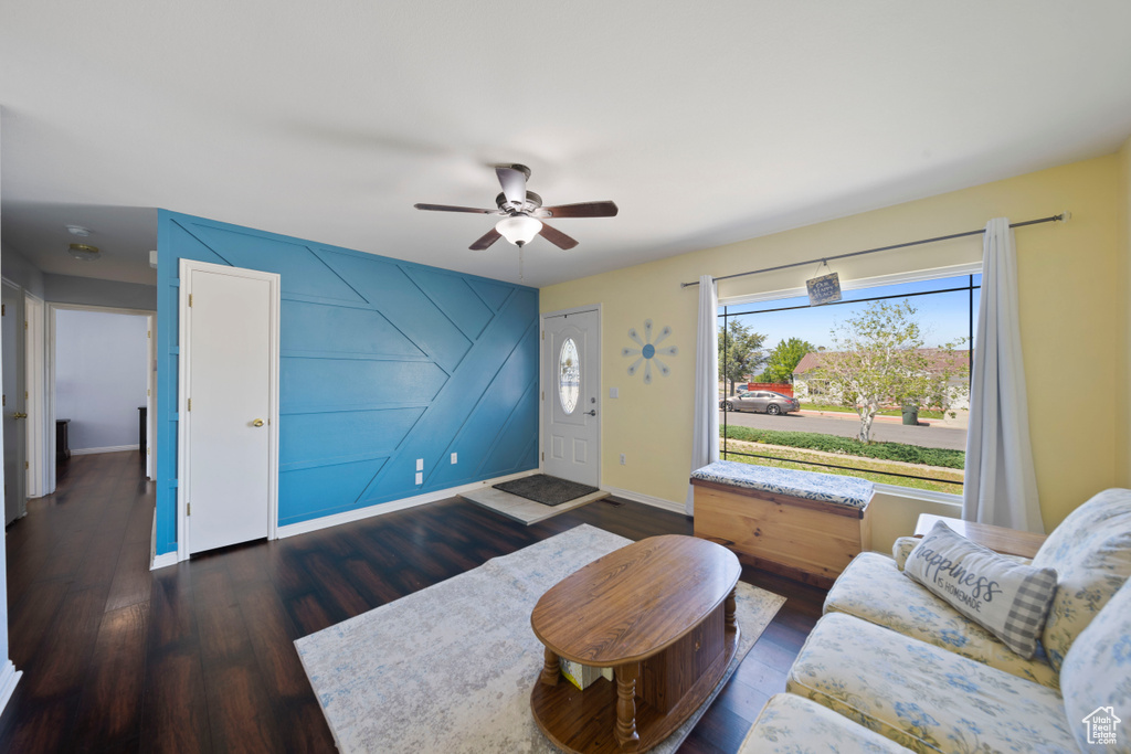 Living room with wood finished floors, a ceiling fan, and baseboards