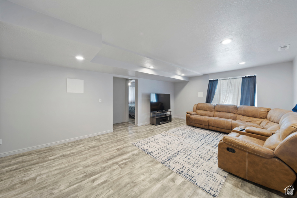 Living room featuring light wood-style floors, baseboards, and recessed lighting