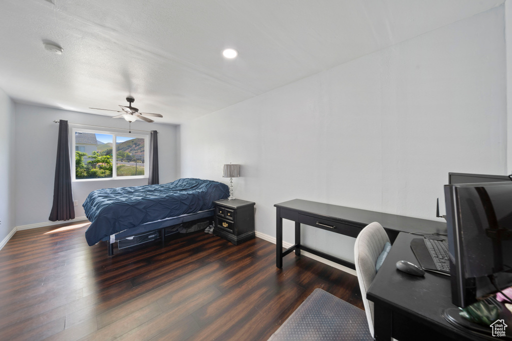 Bedroom with wood finished floors, baseboards, an office area, a ceiling fan, and recessed lighting