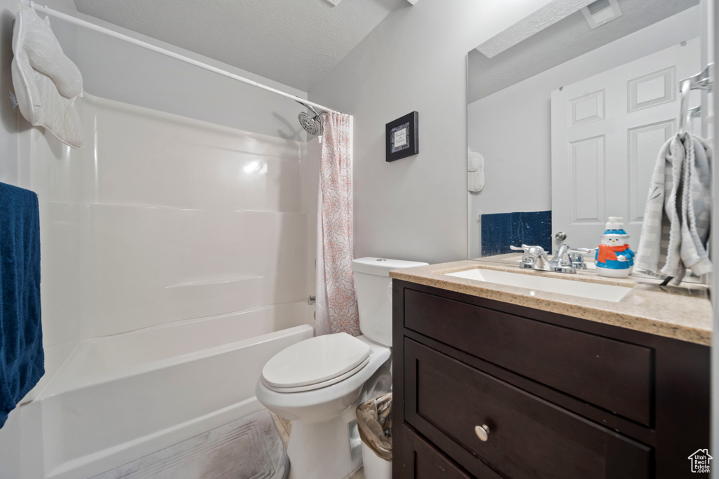Full bathroom with vanity, toilet, and shower / bath combination with curtain