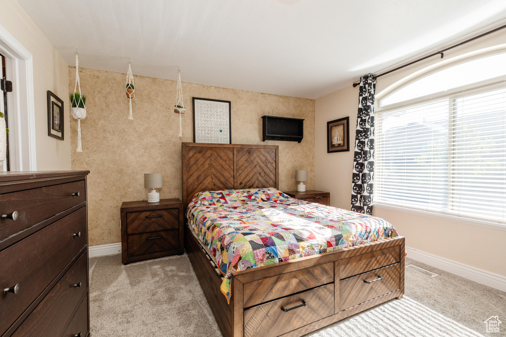 Bedroom featuring light carpet and baseboards