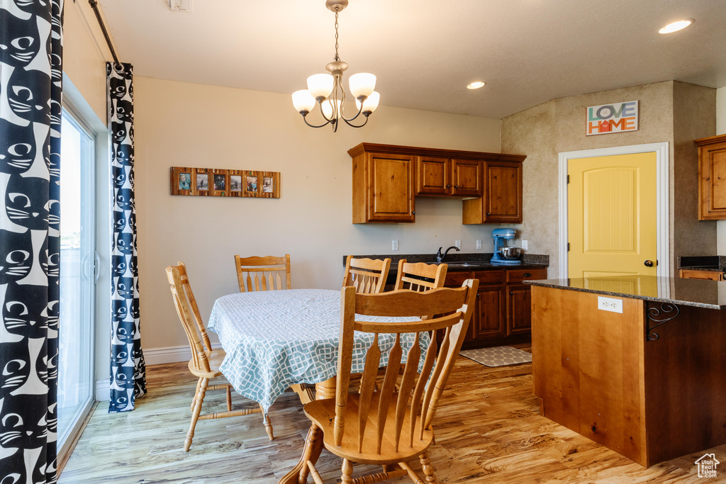 Dining area featuring light wood finished floors, a chandelier, recessed lighting, and baseboards