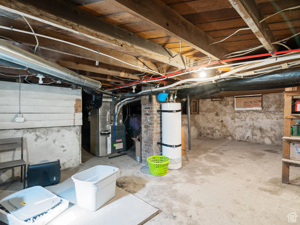 Unfinished below grade area with strapped water heater and heating unit