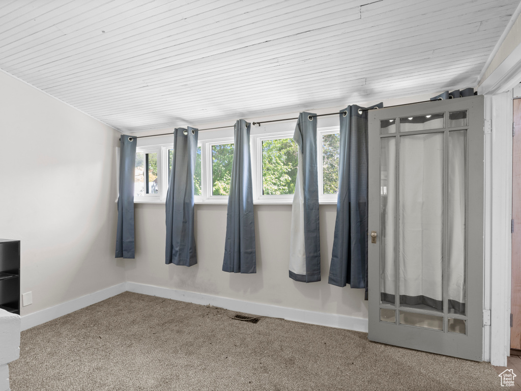 Interior space with multiple windows, carpet floors, baseboards, and wood ceiling