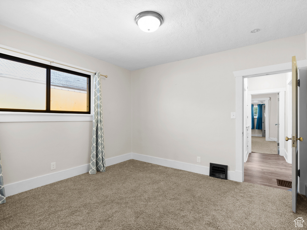 Empty room featuring carpet floors and baseboards