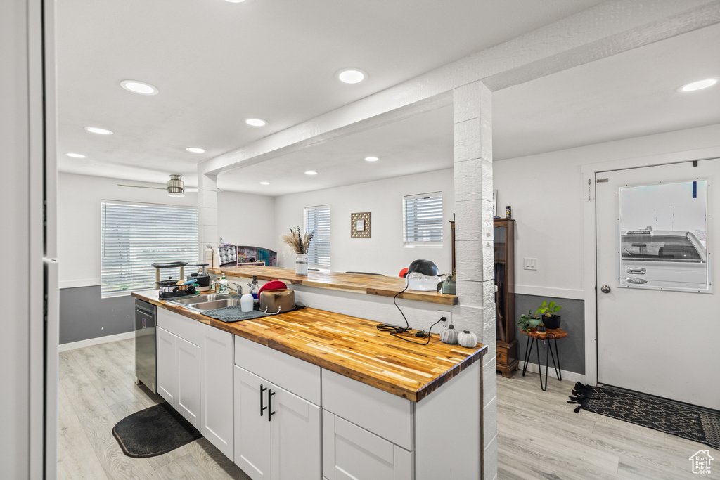 Kitchen with butcher block counters, dishwasher, light wood finished floors, and recessed lighting