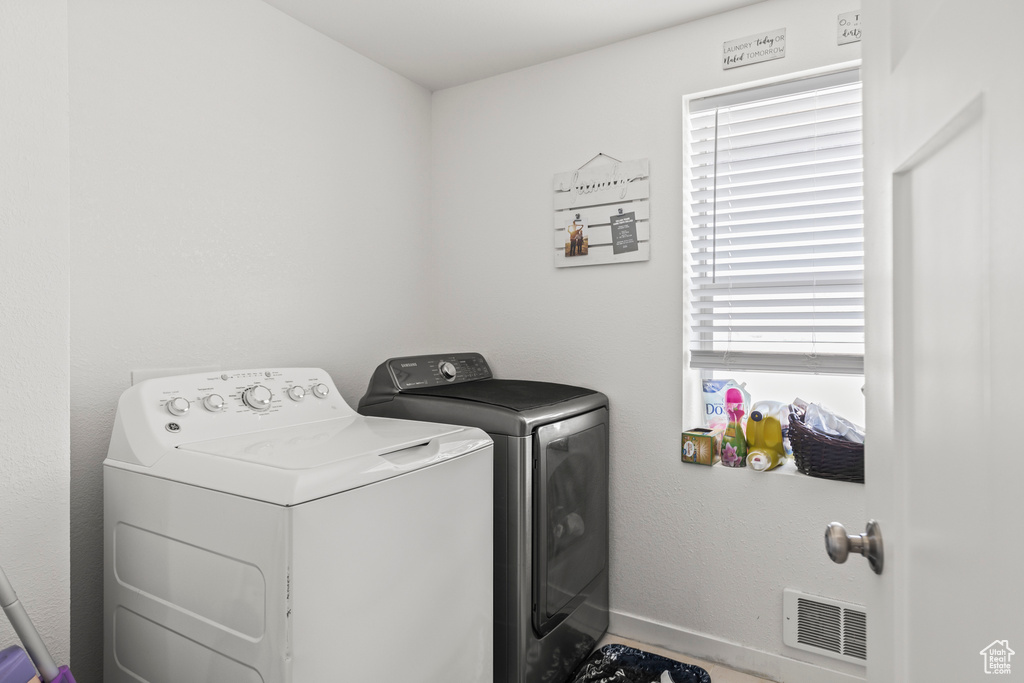 Washroom with washing machine and dryer and baseboards