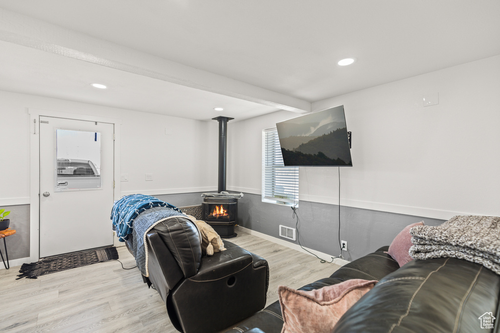 Living room with a wood stove, wood finished floors, recessed lighting, and baseboards