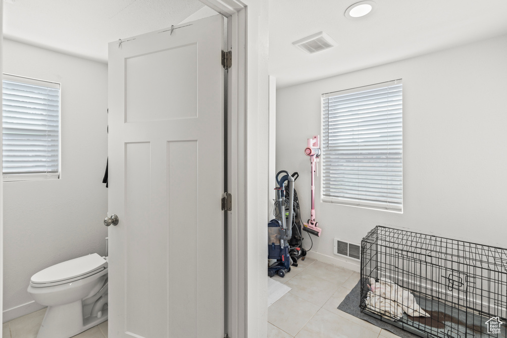 Bathroom featuring toilet, tile patterned flooring, and baseboards