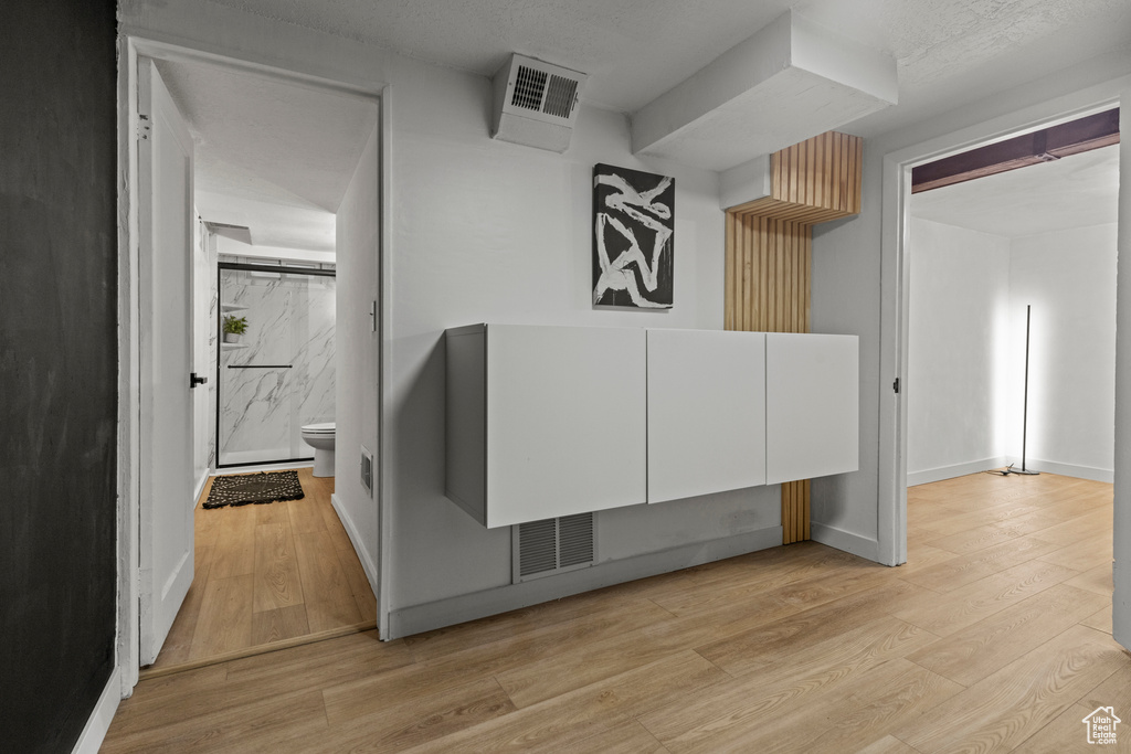 Hallway with light wood-type flooring and baseboards