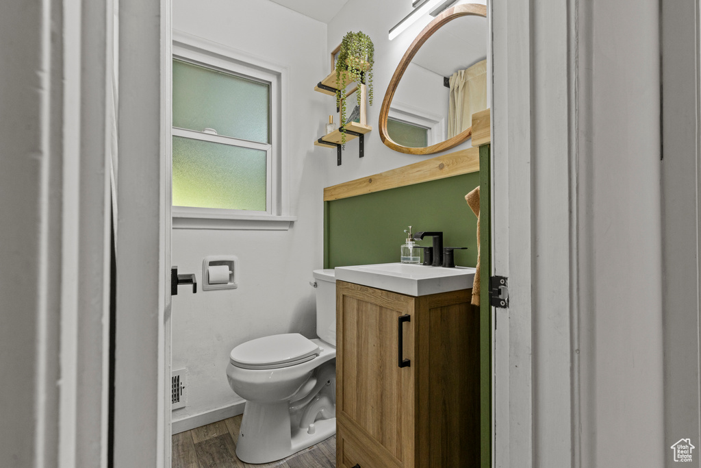 Bathroom featuring toilet, wood finished floors, and vanity