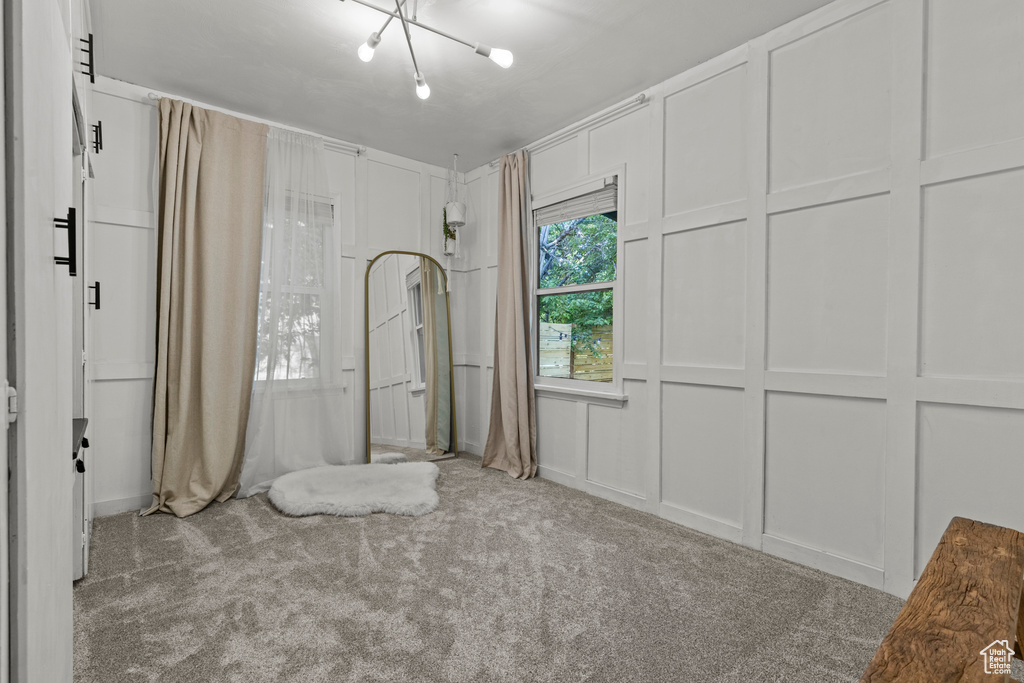 Unfurnished bedroom featuring carpet flooring and a decorative wall