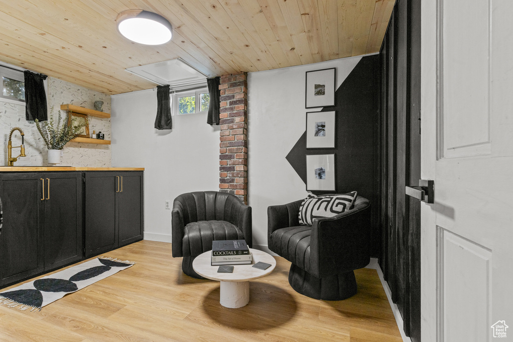 Sitting room with wooden ceiling and light wood-type flooring