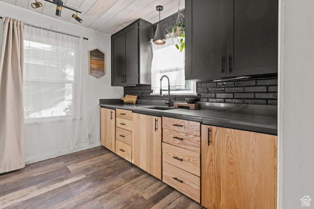 Kitchen with a sink, dark countertops, tasteful backsplash, dark wood-style floors, and light brown cabinets