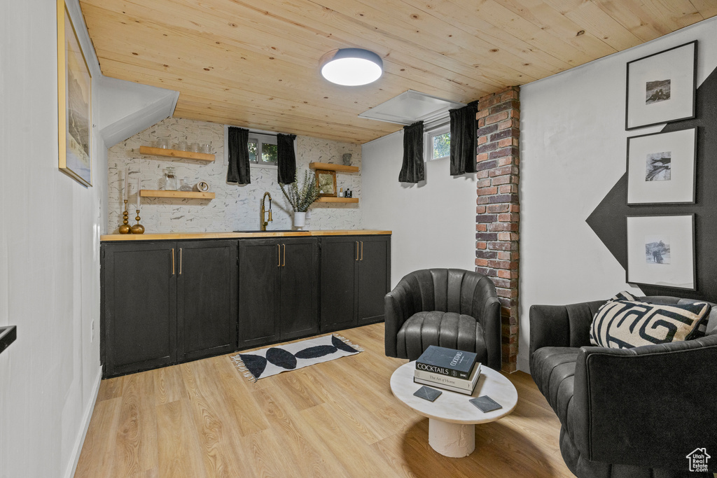 Bar featuring a sink, wood ceiling, and light wood finished floors
