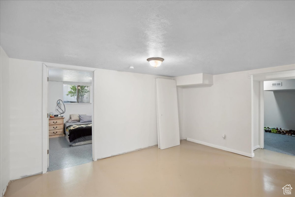 Unfurnished living room featuring baseboards and finished concrete flooring