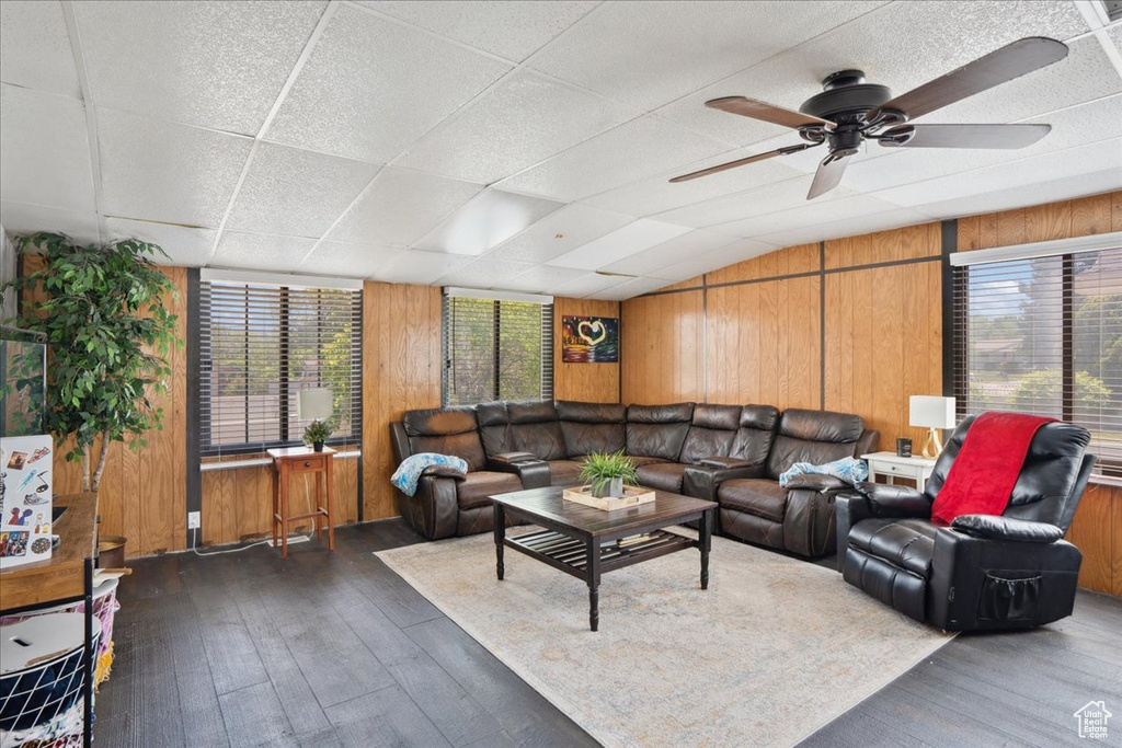 Living area featuring hardwood / wood-style flooring, wooden walls, and ceiling fan