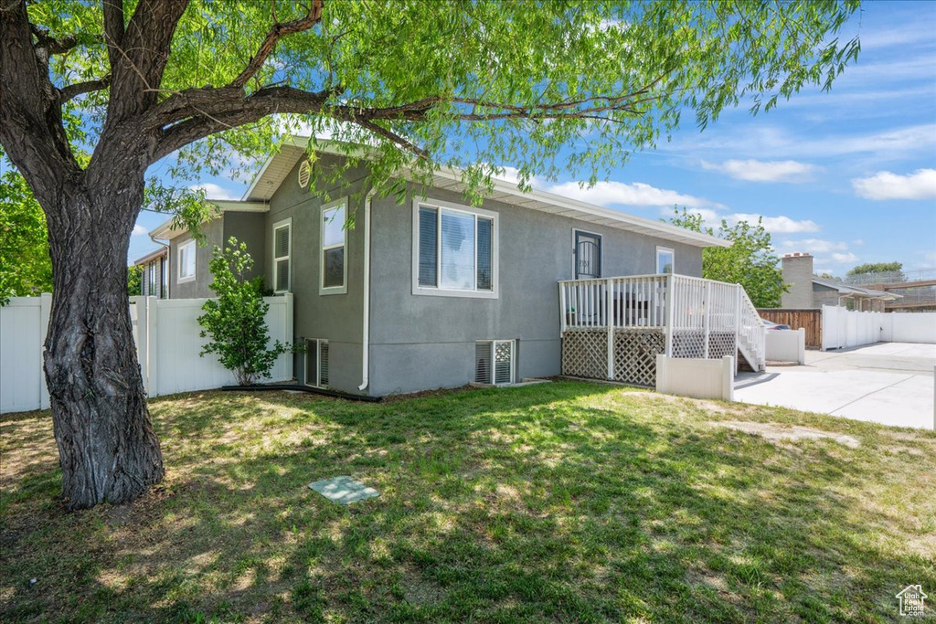 Rear view of property featuring a patio, a wooden deck, and stucco siding