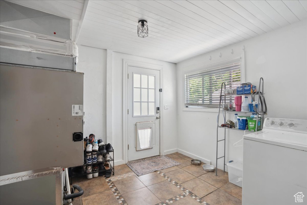 Foyer entrance featuring washer / clothes dryer, inlaid floor details, tile patterned floors, and baseboards