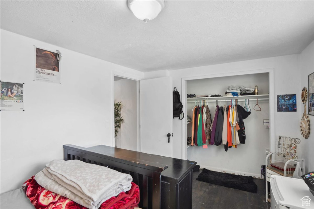 Bedroom with wood finished floors, a closet, and baseboards
