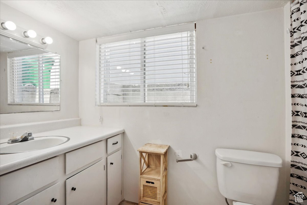 Full bath featuring vanity, toilet, and a shower with curtain