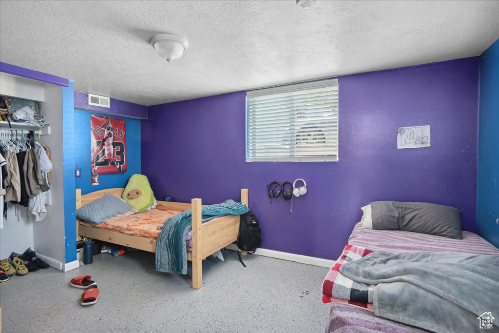 Bedroom with baseboards, a closet, and a textured ceiling
