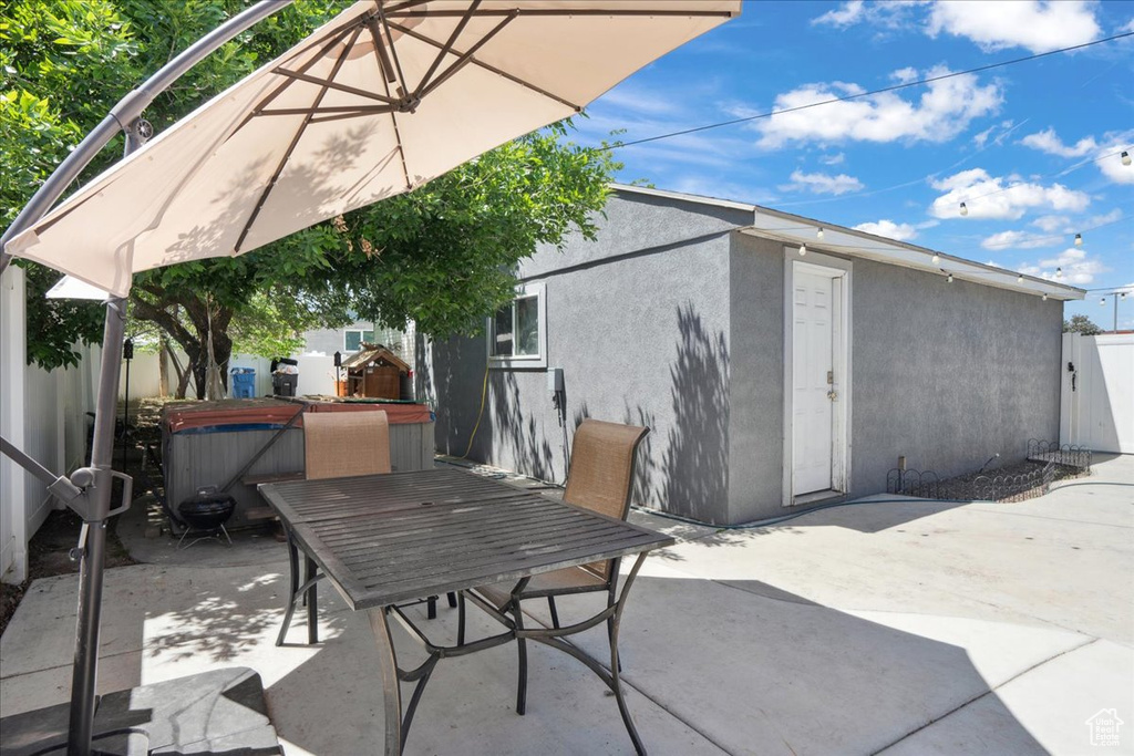View of patio / terrace with a hot tub and outdoor dining space