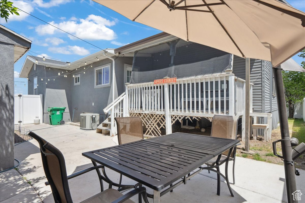 View of patio with outdoor dining space and a wooden deck
