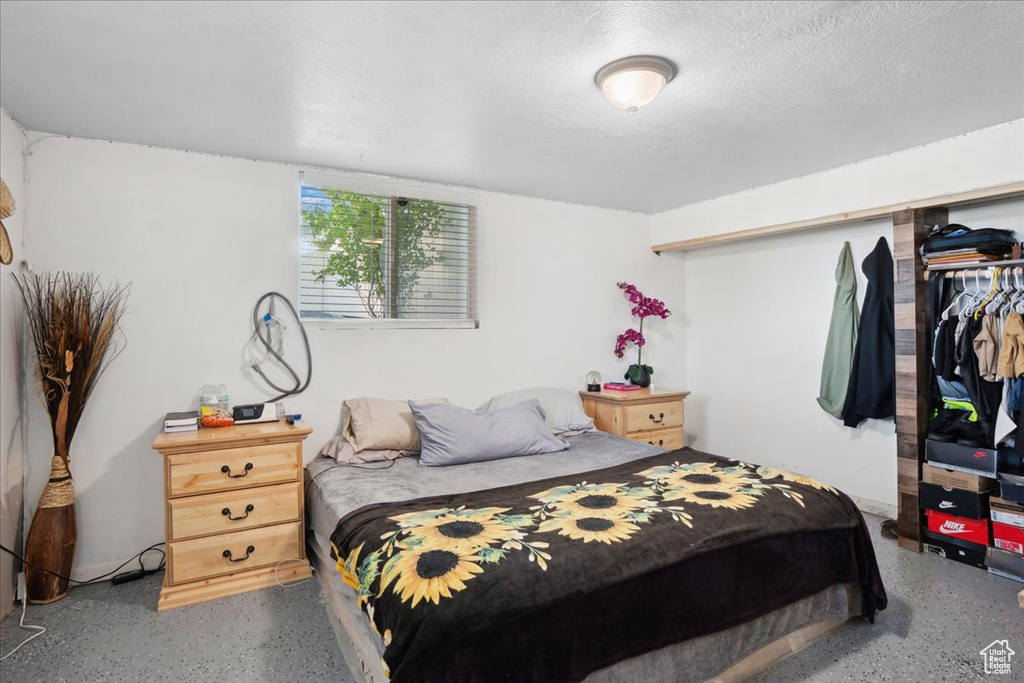 Bedroom with speckled floor and a textured ceiling