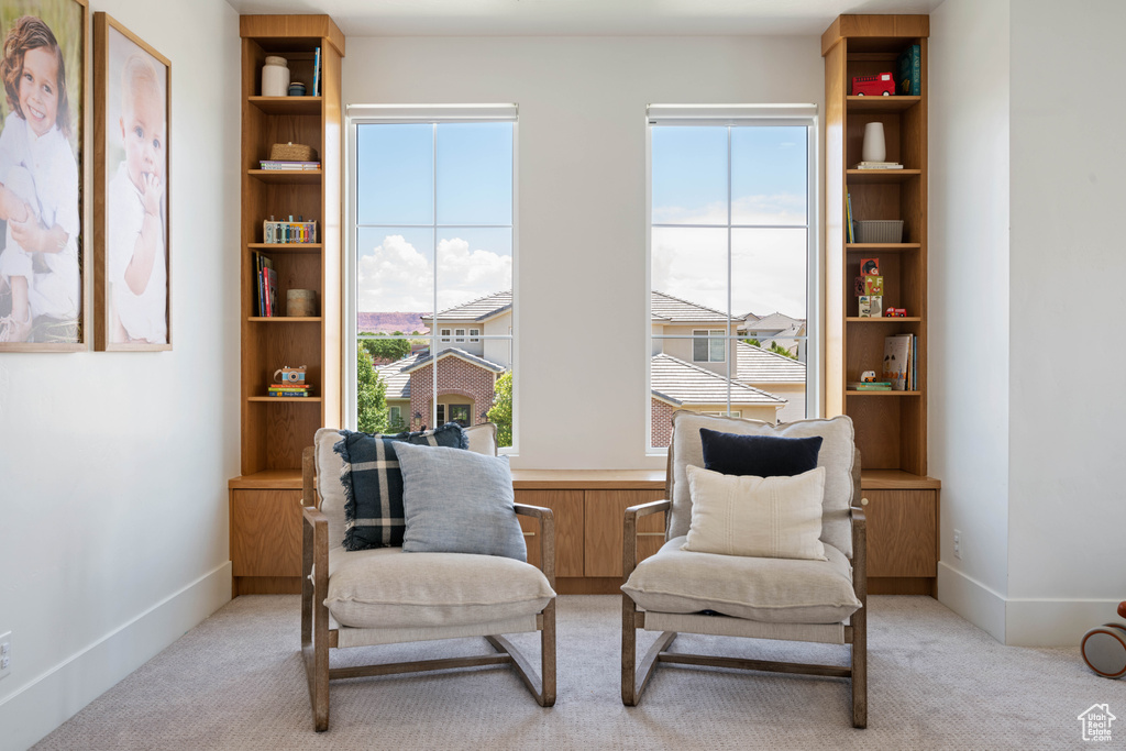Sitting room featuring light colored carpet and baseboards
