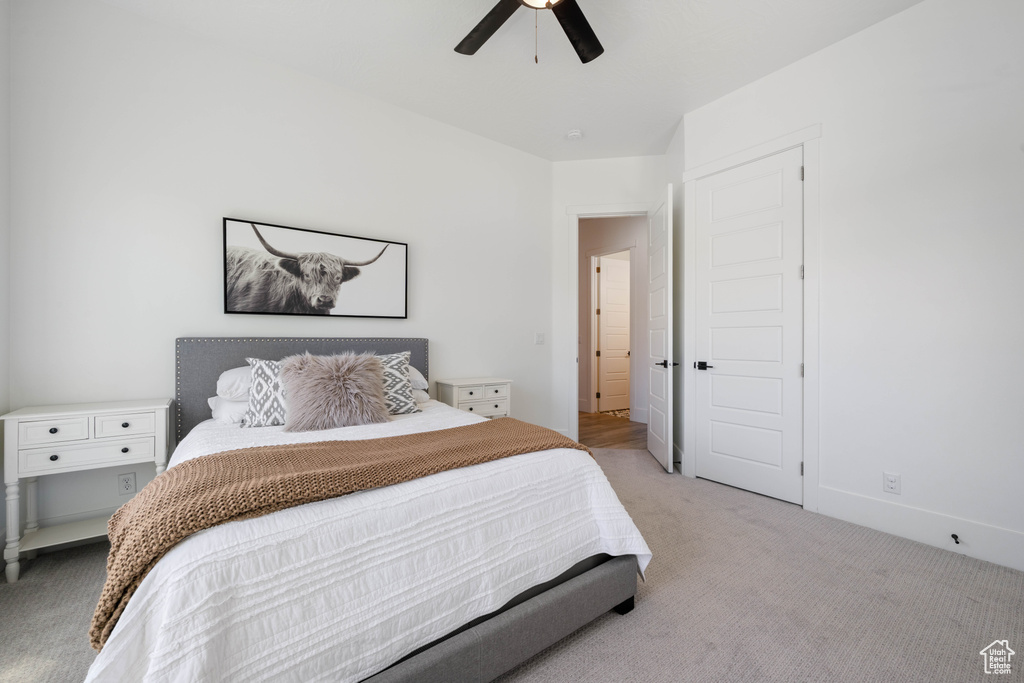 Bedroom with light carpet and a ceiling fan