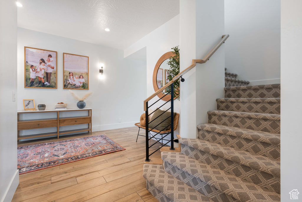Stairway with wood-type flooring, recessed lighting, and baseboards