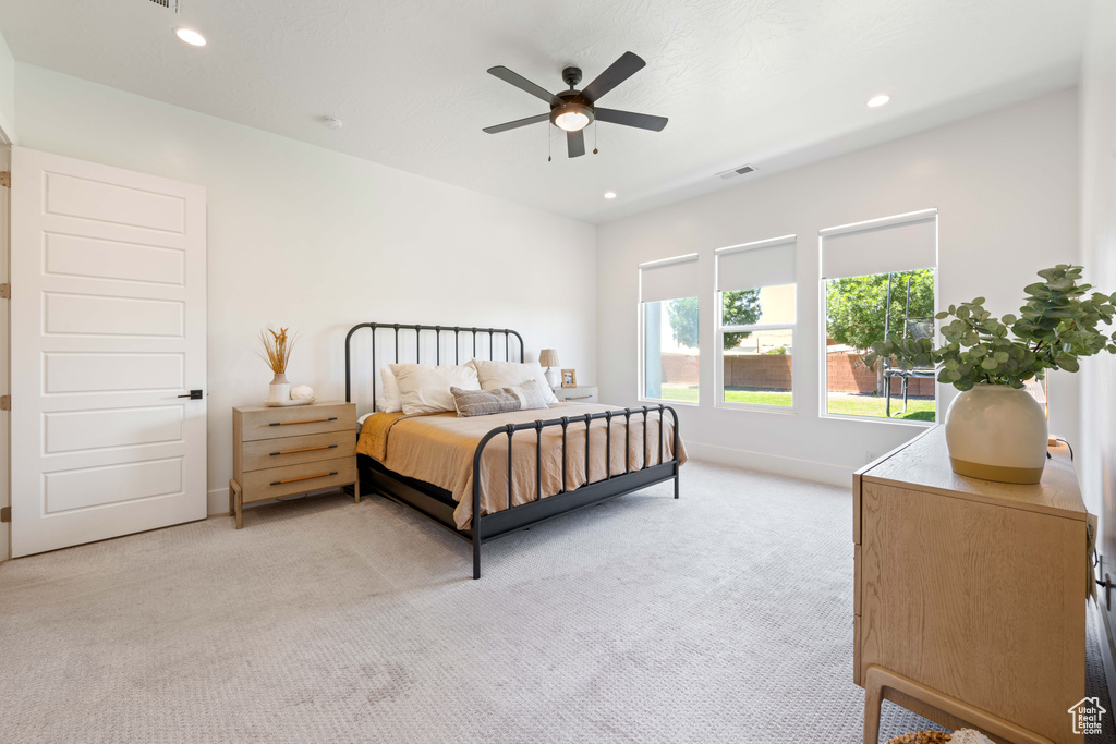 Bedroom with light colored carpet, baseboards, recessed lighting, and ceiling fan