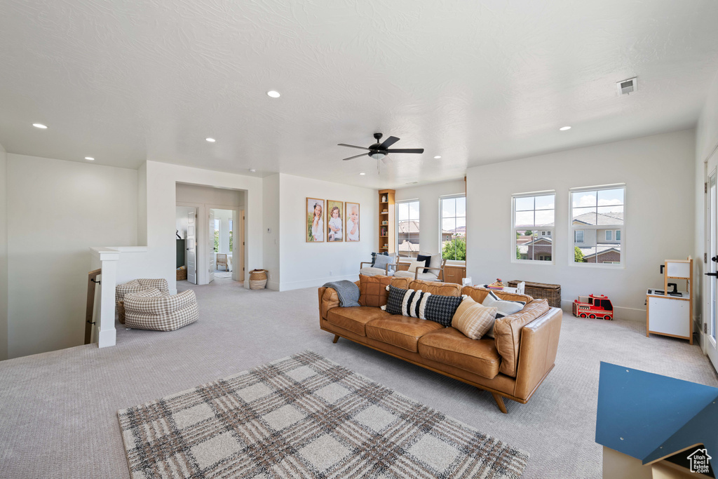 Living area with light carpet, recessed lighting, and ceiling fan