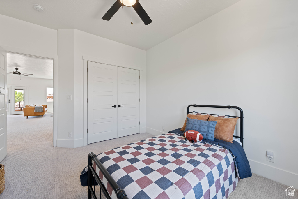Bedroom with carpet flooring, baseboards, a closet, and a ceiling fan