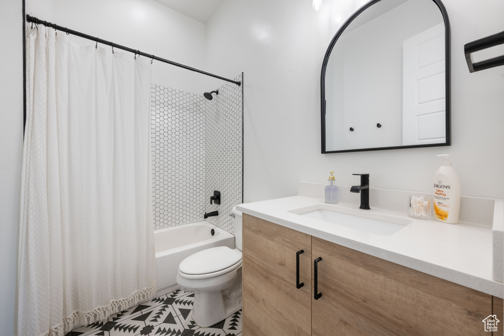 Full bath featuring vanity, shower / bath combo with shower curtain, and toilet
